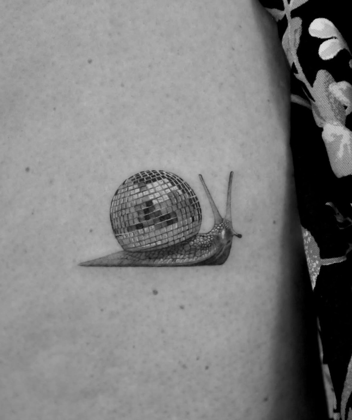 A snail whose shell is a mirrored disco ball.